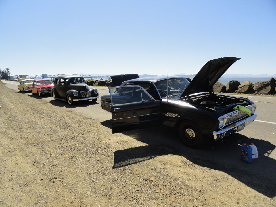 1964 Ford Fairlane and other vintage cars parked on a roadside with hoods open