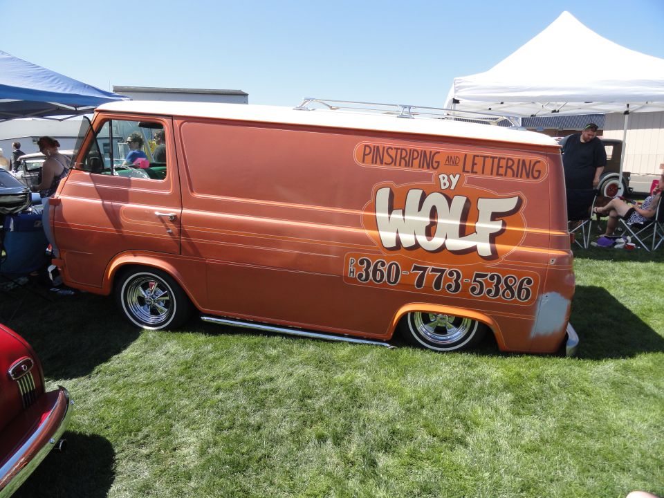 Orange panel van with pinstriping and "WOLF" lettering, phone number 360-773-5386 visible