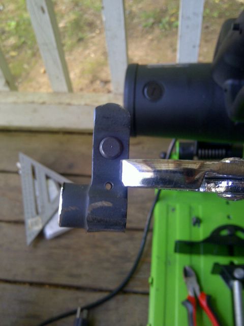 1989 Ford Bronco - A metal part is shown with a shiny rod and a speed square, against a green background.