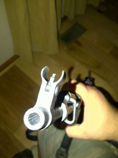 1989 Ford Bronco - Close-up view of a gun barrel and front sight, held by a hand.