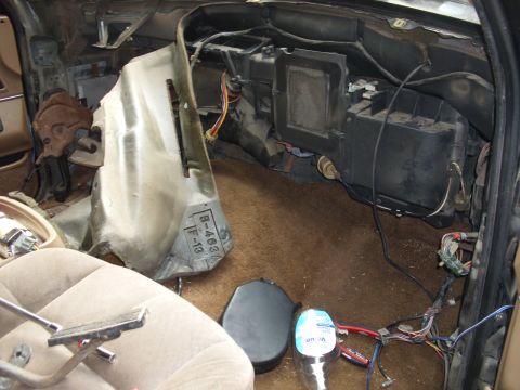 1988 Ford Bronco - The interior of a vehicle is shown with the dashboard disassembled, revealing wiring and HVAC systems.