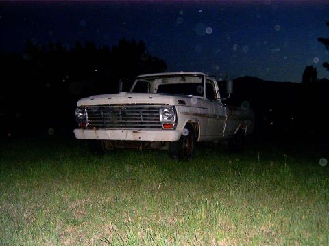 1967 Ford F-250 - A white Ford F-Series truck sits in a grassy field under a dark night sky.