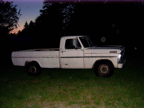 1967 Ford F-250 - A white 1967 Ford F-250 pickup truck sits on a grassy area as the sky darkens.