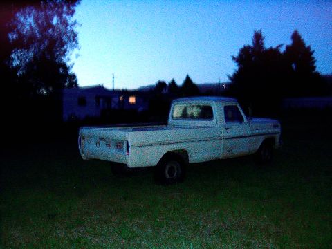 1967 Ford F-250 - A white 1967 Ford F-250 pickup truck sits in a grassy area under a twilight sky.