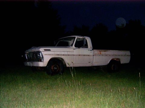1967 Ford F-250 - A 1967 Ford F-250 pickup truck sits in a field under a full moon.