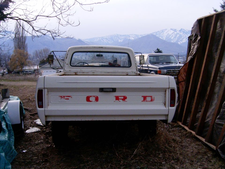 White 1967 Ford F-250 pickup truck, rear view, with red "FORD" lettering on tailgate
