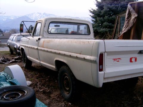 1967 Ford F-250 - A white 1967 Ford F-250 pickup truck is seen from the rear quarter angle, with another vehicle parked behind it.