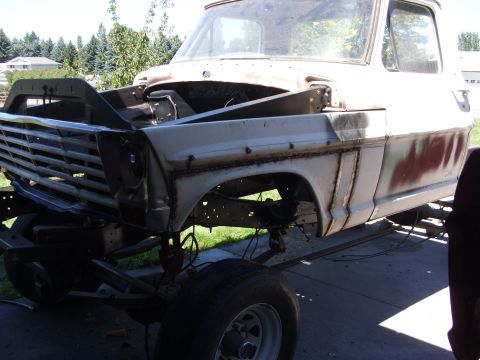 1967 Ford F-250 - The front section of a disassembled truck is shown, with the hood and fenders removed.