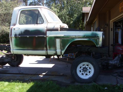 1967 Ford F-250 - A 1967 Ford F-250 truck cab and chassis is shown from the side, in a state of repair with primer and green paint.