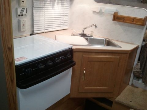 1967 Ford Mustang - Interior view of an RV kitchen area a sink, faucet, and stove.