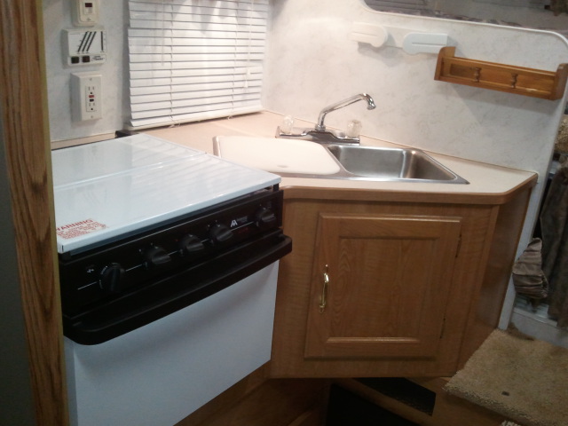 RV interior with sink, faucet, and stove