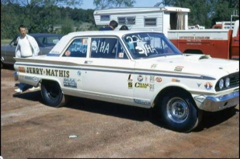 1963 Ford Fairlane - A white 1963 Ford Fairlane drag car is parked outdoors with racing decals and numbers on its windows.