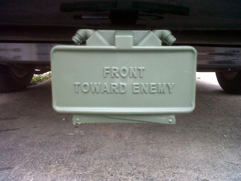 1999 Ford Crown Victoria - An anti-tank mine with the warning 'FRONT TOWARD ENEMY' is visible mounted beneath a vehicle.