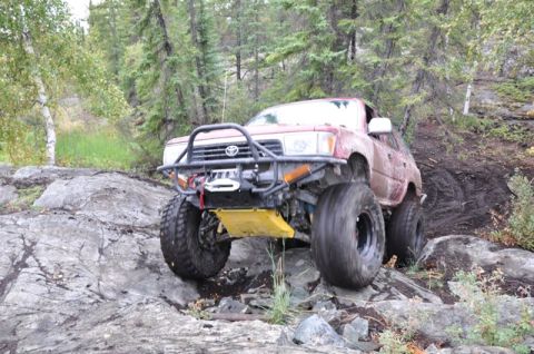 1986 Ford F-150 - This heavily modified Toyota pickup truck navigates a challenging rocky trail.