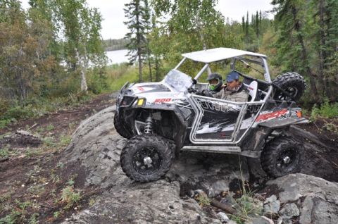 1986 Ford F-150 - This side-by-side ATV navigates a rocky trail in a wooded area near a lake.