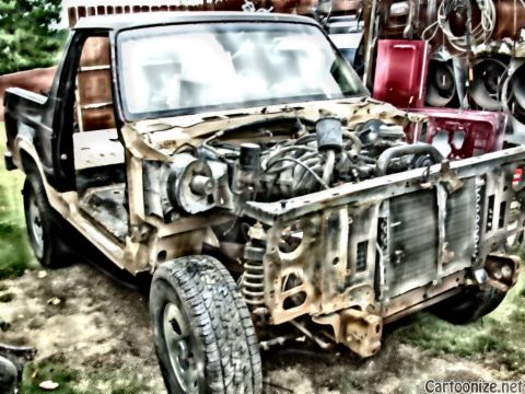 1983 Ford Bronco - This disassembled Ford pickup truck is missing its front grille and hood, revealing the engine and radiator.