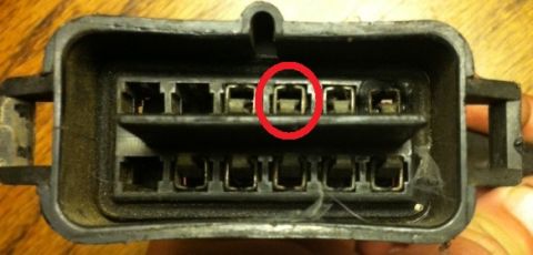1967 Pontiac Grand Prix - Close-up of a black electrical connector with metal terminals, showing a red circle around one terminal.