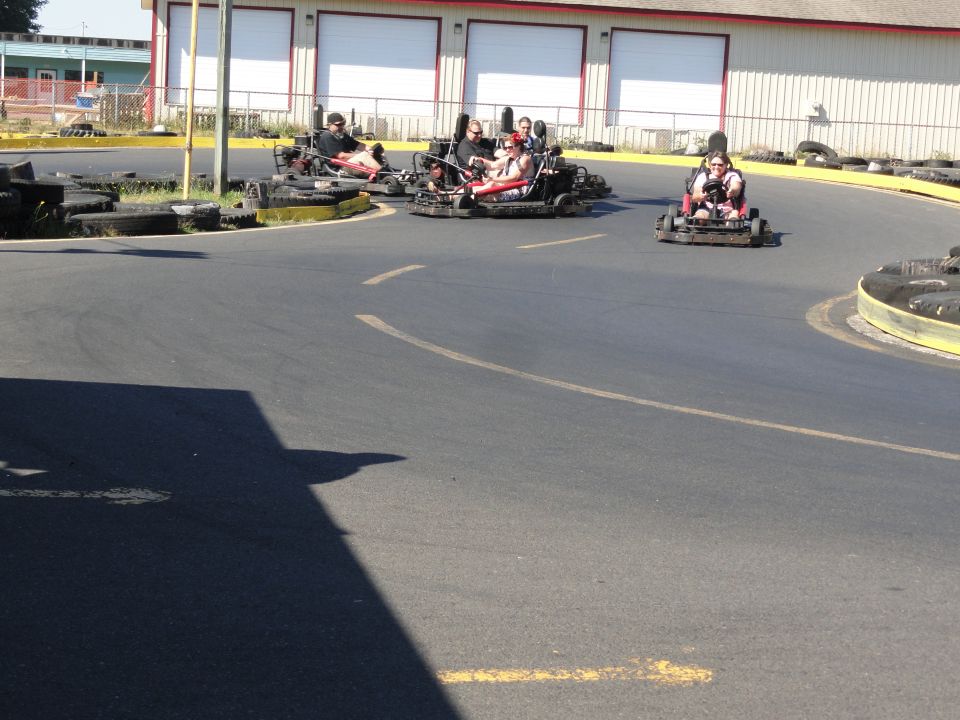 Go-karts racing on an outdoor track with people driving