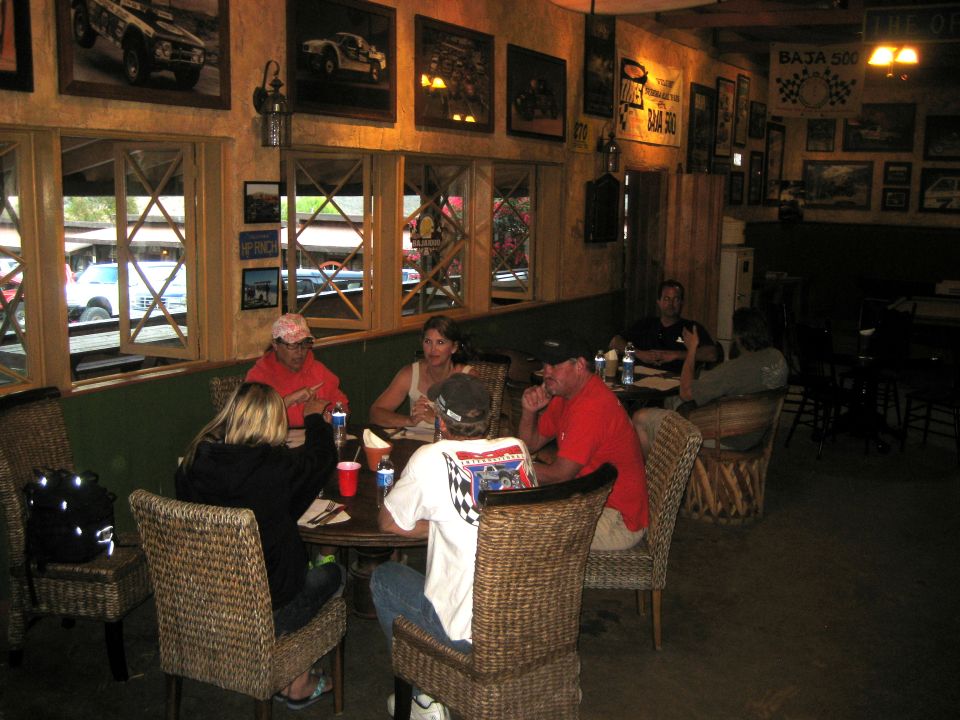 Restaurant interior with people at tables, Baja 500 memorabilia on walls