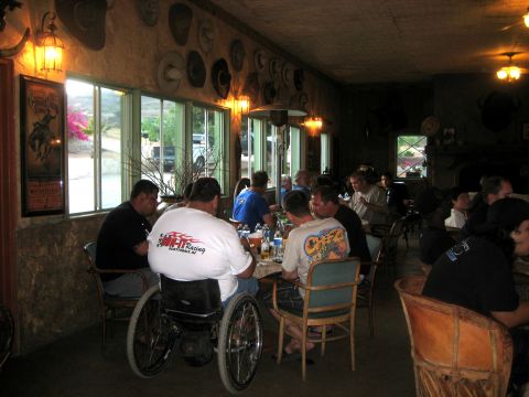 1996 Ford Bronco - A black SUV is seen through the window of a restaurant with people dining inside.