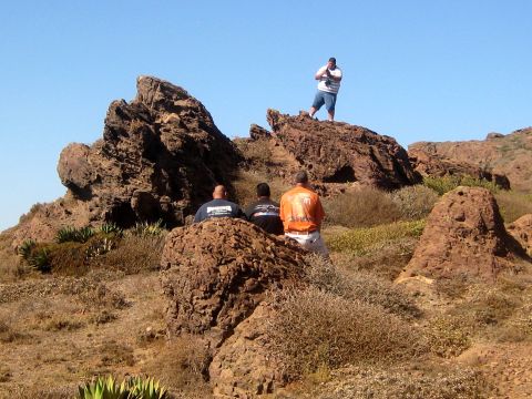 1996 Ford Bronco - A group of people are taking a break on a rocky outcrop, with one person documenting the scene from a higher vantage point.
