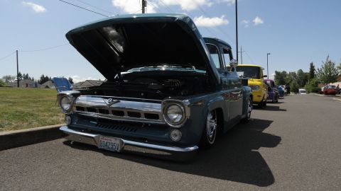 1964 Ford Fairlane - A line of classic trucks are parked on a sunny day, with the front truck's hood raised.