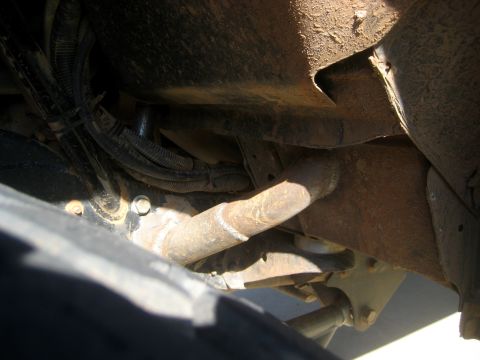 1996 Ford Bronco - Close-up of vehicle undercarriage showing suspension parts and wiring loom.