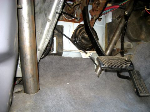 1996 Ford Bronco - Close-up of the driver's side footwell, revealing pedals and part of a roll cage structure.