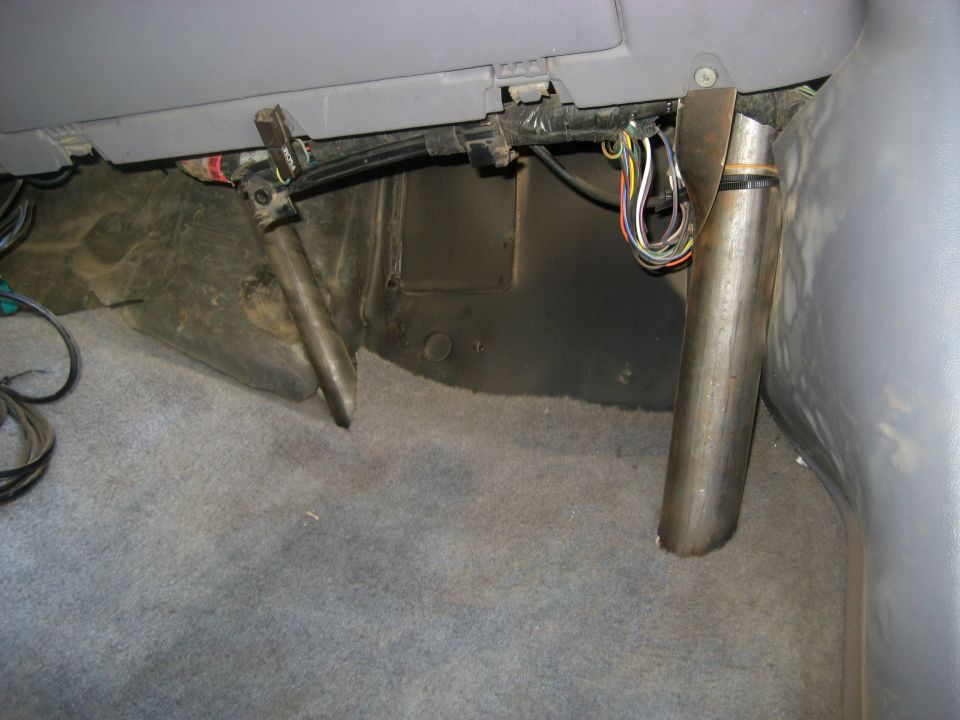 Vehicle interior with exposed wires and metal rods near the floor