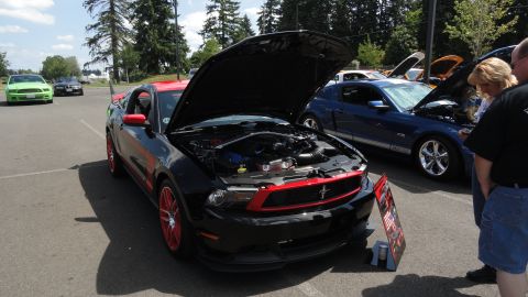 1964 Ford Fairlane - Several Ford Mustangs are displayed with hoods open at an outdoor car show.