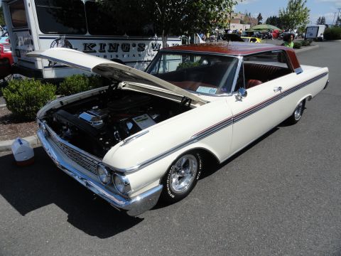 1964 Ford Fairlane - A white 1962 Ford Galaxie coupe with a brown roof is displayed with its hood open, showing the engine bay.