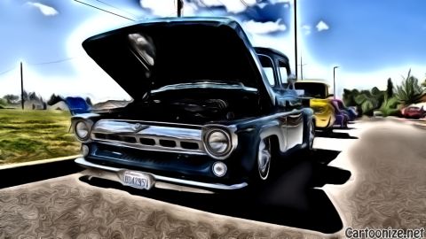 1964 Ford Fairlane - A dark blue pickup truck from 1955 is parked with its hood open, showing the engine. Other vehicles are visible in the background.