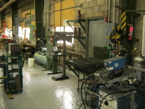 1994 Ford Bronco - A busy workshop environment filled with various machinery and tools, including a drill press and welding equipment.