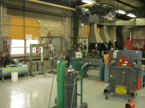 1994 Ford Bronco - A busy workshop scene displays various industrial tools and equipment, including an air compressor and welding tanks.