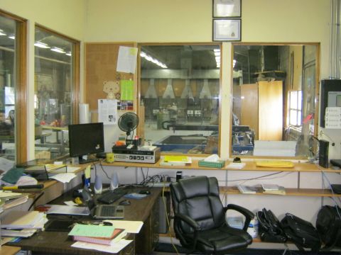 1994 Ford Bronco - An office space with a cluttered desk and a view into a manufacturing area.