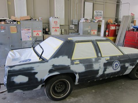 1991 Ford LTD Crown Victoria - This police car is in a garage, prepped for paint with primer and masking tape on the windows.