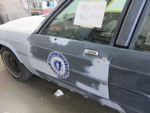 1991 Ford LTD Crown Victoria - Side view of a Massachusetts State Police car door undergoing bodywork.