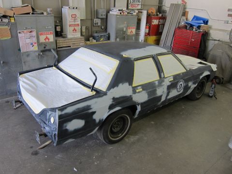 1991 Ford LTD Crown Victoria - A 1991 Ford Crown Victoria is prepped for painting in a workshop, showing its bodywork and taped windows.