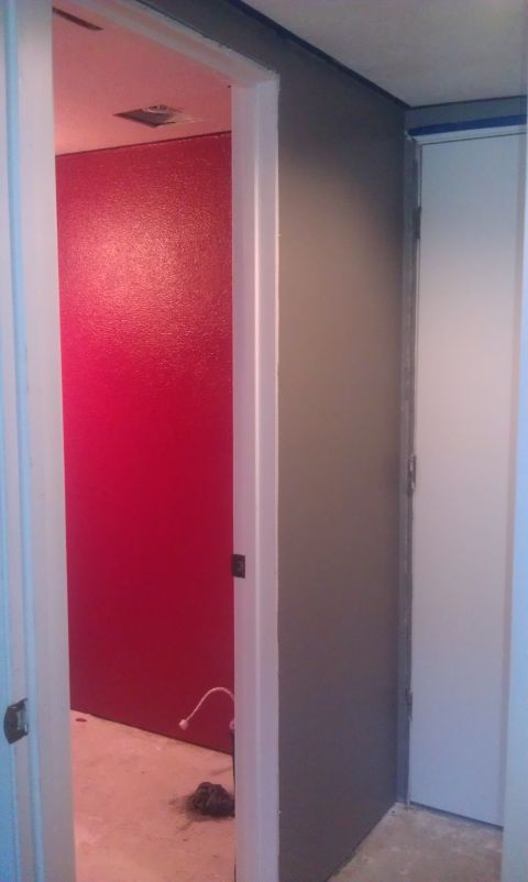 1989 Ford Bronco - A view down an interior hallway showing a red wall and a white door.