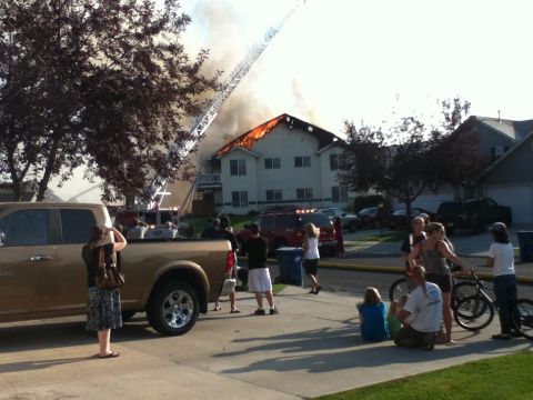 2006 Ford E350 - Onlookers gather as a house fire rages, with a fire department ladder truck in position.