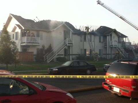 2006 Ford E350 - Firefighters are working to extinguish a fire at an apartment complex, with police tape cordoning off the area.