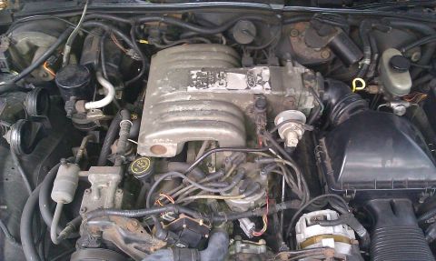 1991 Mercury Grand Marquis - The engine bay of a 1991 Mercury Grand Marquis is pictured, revealing its V8 engine components.