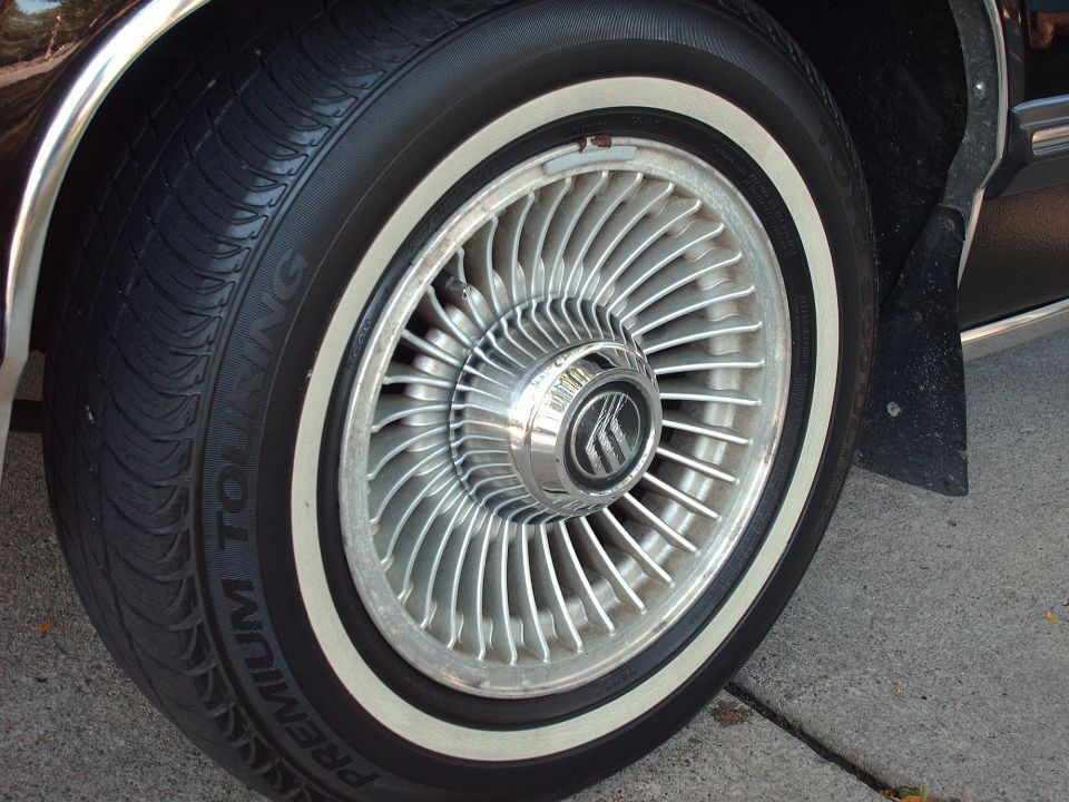 1991 Mercury Grand Marquis wheel with chrome hubcap and whitewall tire