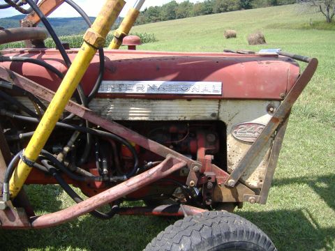 1988 Ford Bronco - This International 240 tractor is shown from the side with visible hydraulic lines and a red engine block.