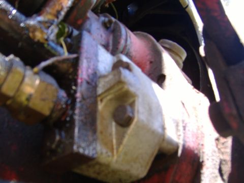 1988 Ford Bronco - A close-up view of a hydraulic pump assembly, showing various hoses and mechanical components.