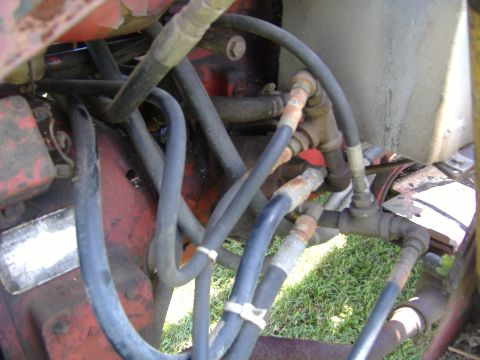 1988 Ford Bronco - Close-up view of hydraulic hoses and fittings on a red tractor.