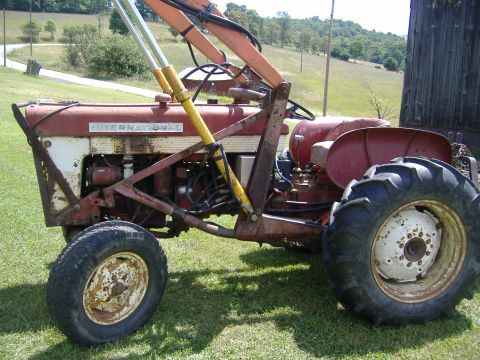 1988 Ford Bronco - This International Harvester tractor, equipped with a front loader, is seen from the side in a grassy field.