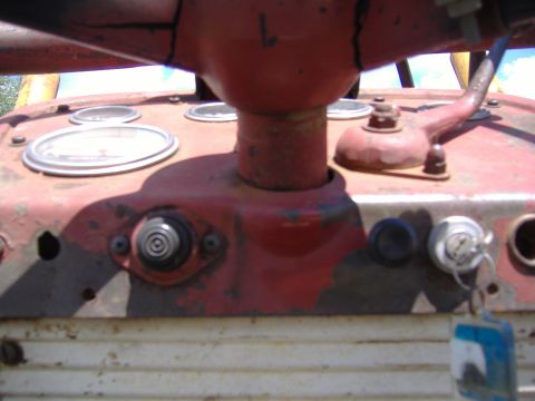 1988 Ford Bronco - Close-up of a tractor's dashboard, showing gauges and a key in the ignition.