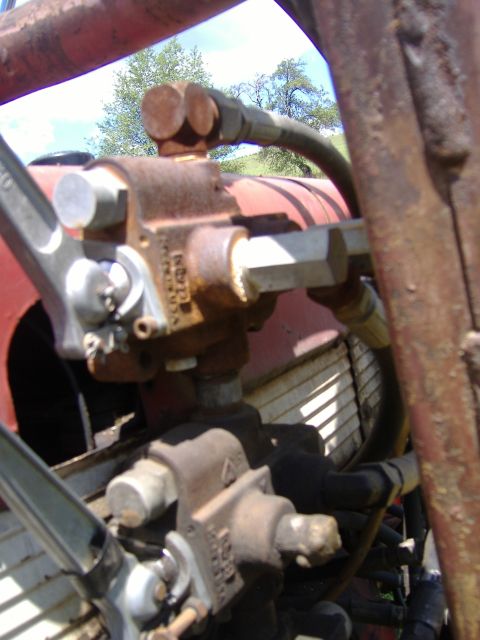 1988 Ford Bronco - Detail of hydraulic pump and hoses, likely from a tractor, with visible rust and wear.