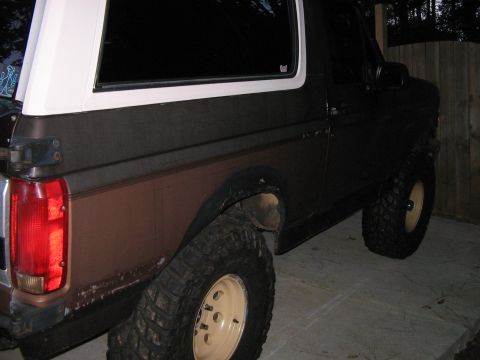 1992 Ford Bronco - Rear view of a 1992 Ford Bronco with off-road tires and a two-tone paint scheme.
